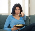 Bored woman changing TV channels with remote control