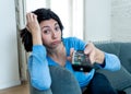 Bored woman changing TV channels with remote control