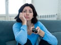 Bored woman changing TV channels with remote control