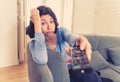 Bored woman changing TV channels with remote control