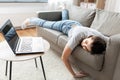 Bored woman with laptop lying on sofa at home Royalty Free Stock Photo