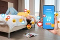 A bored woman is lying on the bed. Hand with a smartphone on the right. Concept of online Internet shopping