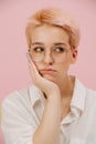 Bored woman with short dyed blond hair leaning on her hand Royalty Free Stock Photo