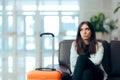 Bored Woman with Suitcase in Airport Waiting Room Royalty Free Stock Photo