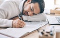 Bored, writing and diary with a business man lying on his desk at work while making note of an appointment. Schedule Royalty Free Stock Photo