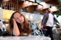 bored yawn young teenage girl falls asleep in a cafe expect a friend lean on the arm close her eyes cool she throw us Royalty Free Stock Photo