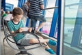 Bored 7 years old boy child waiting for his plane Royalty Free Stock Photo