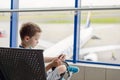 Bored 7 years old boy child waiting for his plane Royalty Free Stock Photo