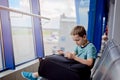 Bored 7 years old boy child waiting for his plane Royalty Free Stock Photo