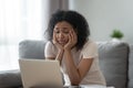 Bored african girl tired of learning with laptop at home