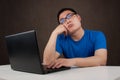 Bored young asian man working with his computer Royalty Free Stock Photo