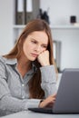 Bored young business woman working with laptop. Royalty Free Stock Photo