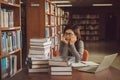 Bored young female student sitting at table in a campus open space library. Education concept Royalty Free Stock Photo