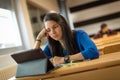 Bored young female student at university classroom