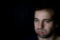 Bored young man, sigh. black background Royalty Free Stock Photo