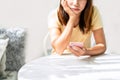 Bored young woman looking disappointed at her smart phone while waiting someone in restaurant Royalty Free Stock Photo