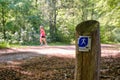 Borger,the Netherlands-May 18,2020:Nordic walking hiking trail sign along side an old natural stone path in green forest Royalty Free Stock Photo