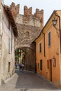 Tourists walking through medieval fortifications of Borghetto town, Italy Royalty Free Stock Photo