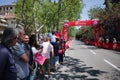 People with pink flags with logo of Giro d`Italia stand along street waiting for for peloton of cyclists