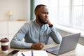 Bored Black Businessman Sitting At Laptop Working In Modern Office Royalty Free Stock Photo
