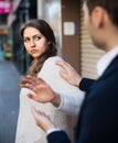 Boring male person accosting to female at crowded street Royalty Free Stock Photo