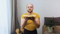 A boring man with a funny facial expression picks up a plate of burrito food and looks admiringly at the camera