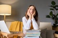 Boring sad young woman studying at home sitting on couch in living room with pc computer and books has crisis in her education Royalty Free Stock Photo