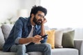 Boring Show. Portrait Of Upset Young Indian Guy Watching TV At Home,