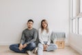 Boring and tired faces of lover sit on the floor of empty room. Royalty Free Stock Photo