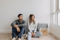 Boring and tired faces of lover sit on the floor of empty room. Royalty Free Stock Photo