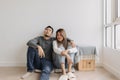 Boring and tired faces of lover sit on the floor of empty room.