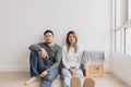 Boring and tired faces of lover sit on the floor of empty room. Royalty Free Stock Photo