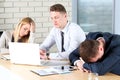 Boring work. Young business people looking bored while sitting together at the table and looking away Royalty Free Stock Photo