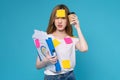 woman holding document file with coffee cup and a sticky note on the face, stand on studio shot blue background.