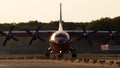 UR-CSI Cavok Airlines Antonov An-12A four-engined turboprop aircraft in the sunset rays running on the runway of Borispol Internat