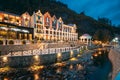 Borjomi, Georgia. Crowne Plaza Borjomi Hotel House And Pedestrian Bridge Over River Borjomula At Autumn October Evening