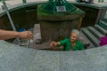 BORJOMI, GEORGIA - JULY 26, 2019: Unidentified woman takes water from Borjomi mineral