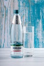 Borjomi glass bottle, Georgian mineral water on turquoise wood background. Healthy beverage that eliminates heartburn. Logo, brand