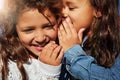 Born sisters, became the best of friends. a young girl whispering in her sisters ear. Royalty Free Stock Photo