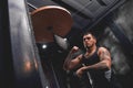 Born to win. Muscular tattooed athlete in sports clothing training hard on punching speed bag to become a champion