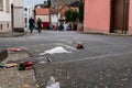 Trash recklessly dumped on the street after a carnival parade. People in costumes carelessly celebrating in blurred background