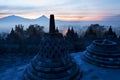 Borobudur temple with Buddha statue, bell stupas and volcano in background