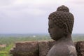 Buddha statue overlooking surroundings at Borobudur temple at sunrise in Java Indonesia Royalty Free Stock Photo