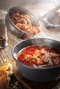 Borsch is poured into a bowl from a ladle from which steam, a traditional Ukrainian vegetable soup made from beets