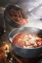 Borsch is poured into a bowl from a ladle from which steam, a traditional Ukrainian vegetable soup made from beets