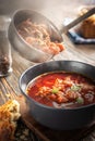 Borsch is poured into a bowl from a ladle from which steam, a traditional Ukrainian vegetable soup made from beets