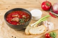 Borscht in a plate with lard, bread and green onions on a light wooden background close-up Royalty Free Stock Photo