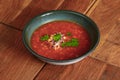 Borscht. Red Ukrainian Russian soup in bowl with sour cream and green onion, isolated on wooden background. Royalty Free Stock Photo