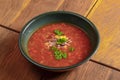 Borscht. Red Ukrainian Russian soup in bowl with sour cream and green onion, isolated on wooden background. Royalty Free Stock Photo