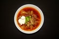 Borscht soup in a white bowl on dark wooden background. Top view. Famous traditional Ukrainian and Russian borshch soup with beetr Royalty Free Stock Photo